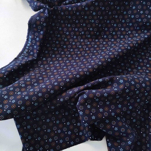Dunkelblauer Feincord von Kokka mit kleinen Blüten in Hellblau, Rost und Creme aus 100 % Baumwolle.