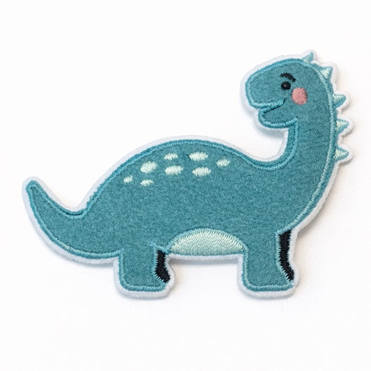 Bestickter Brontosaurus-Aufnäher aus Velours in Petrolblau mit hellblauen Tupfen, kleinen Rückenstacheln, rosa Wange und hellem Bauch auf weißem Hintergrund. Größe 5x7cm, zum Aufbügeln oder Aufnähen.