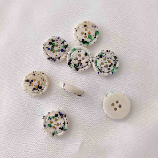 Knopf mit Farbsprenkeln grün
