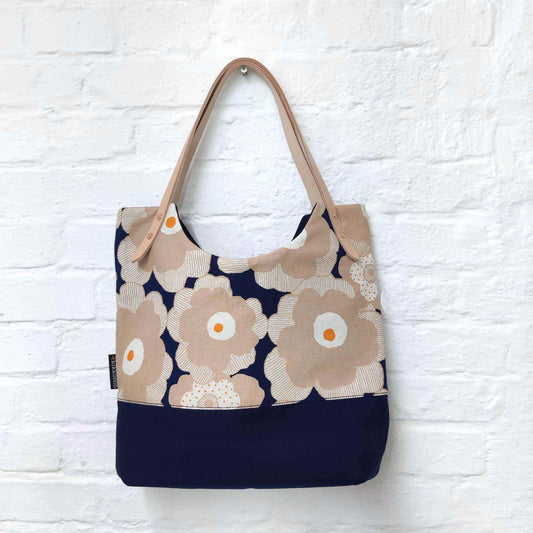 Selbstgenähte Tasche Hanna mit rosa-blauem Blumenstoff, dunkelblauer Unterseite und hellen Lederhenkeln – genäht aus dem Nähset Hanna.