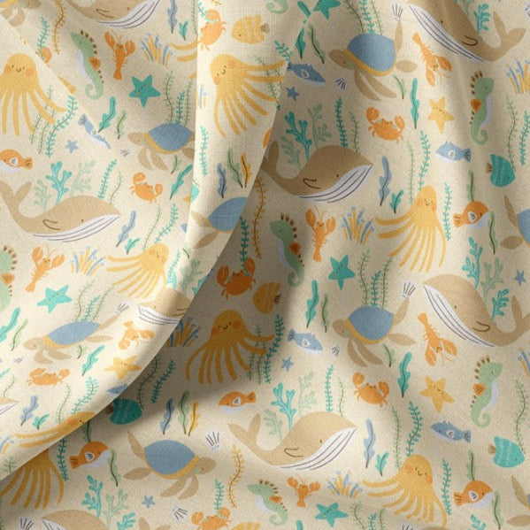 Baumwollstoff mit Meerestieren – Wal, Krake, Schildkröte und Seegras auf cremefarbenem Grund