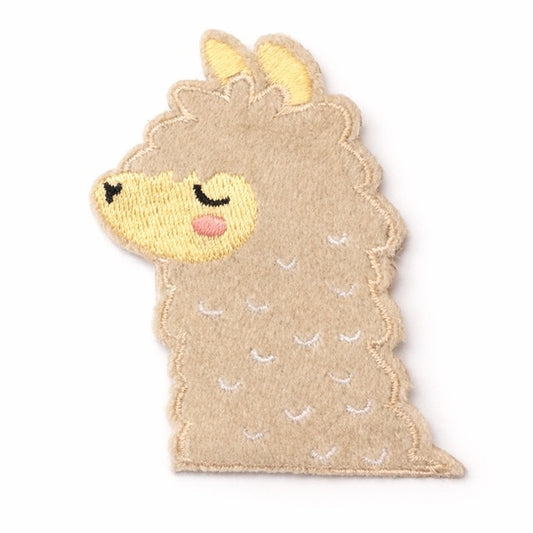 Bestickter Lama-Aufnäher aus Velours in Beige mit gelbem Gesicht, geschlossenen Augen, rosa Wange und gelben Ohren auf weißem Hintergrund. Größe 7x5cm, zum Aufbügeln oder Aufnähen.