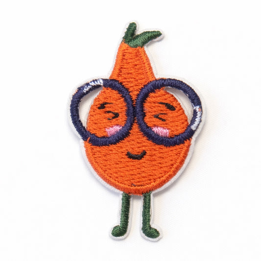Bestickter Aufnäher in Form einer lächelnden Orange mit großer dunkler Brille, grünen Beinchen und Stiel mit Blatt auf weißem Hintergrund. Größe 4x2,5cm, zum Aufbügeln oder Aufnähen.