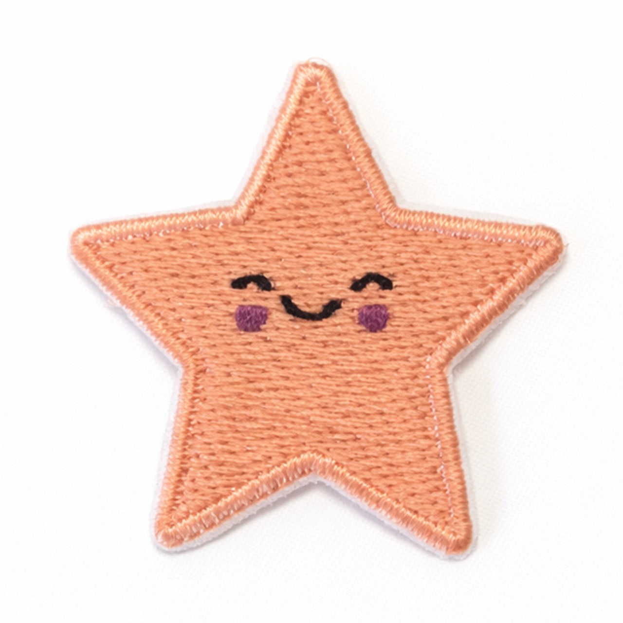 Bestickter Stern-Aufnäher in Apricot mit lächelndem Gesicht, geschlossenen Augen und roten Wangen. Größe 3,5x3,5cm, zum Aufbügeln oder Aufnähen.