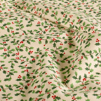 Nahaufnahme mit Stofffalten: Baumwollpopeline mit grünen Stechpalmenblättern und roten Beeren auf cremefarbenem Grund.